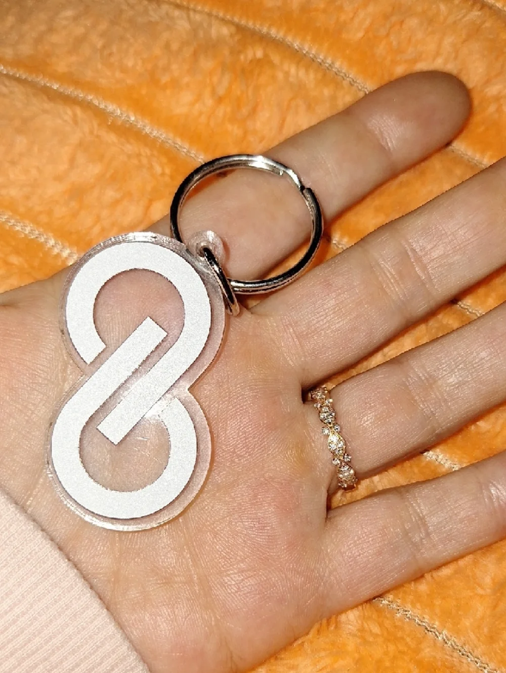 Clear acrylic keychain featuring a bold purple interlocking Poshmark logo.